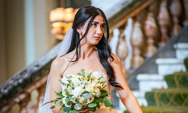 Clermont Victoria - Woman in a wedding dress holding flowers