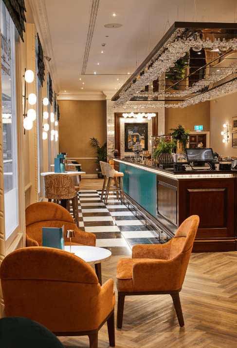 reunion bar with teal counter, hanging glassware, and orange seating