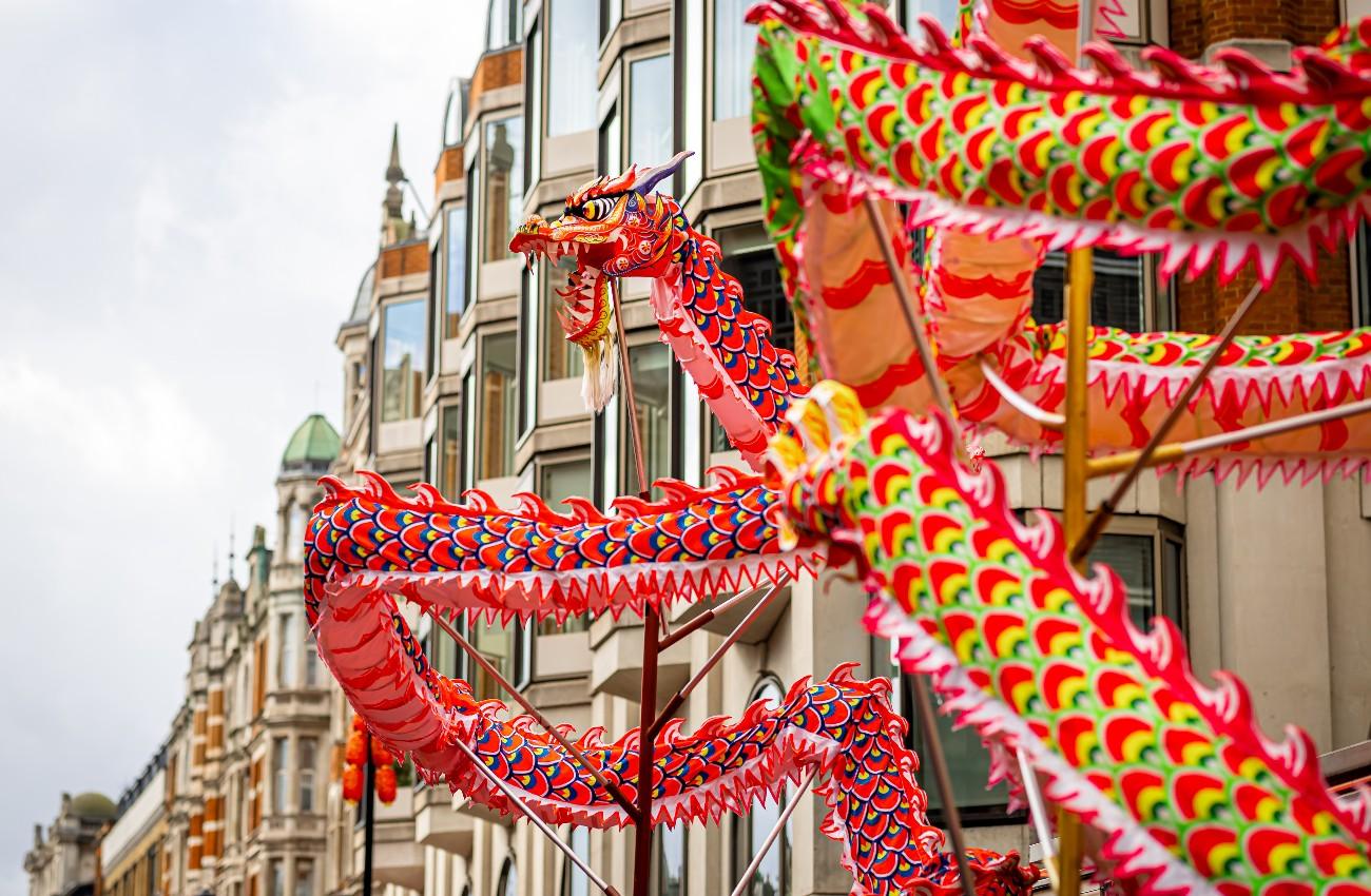 Colourful Chinese dragon decoration displayed above a city street.
