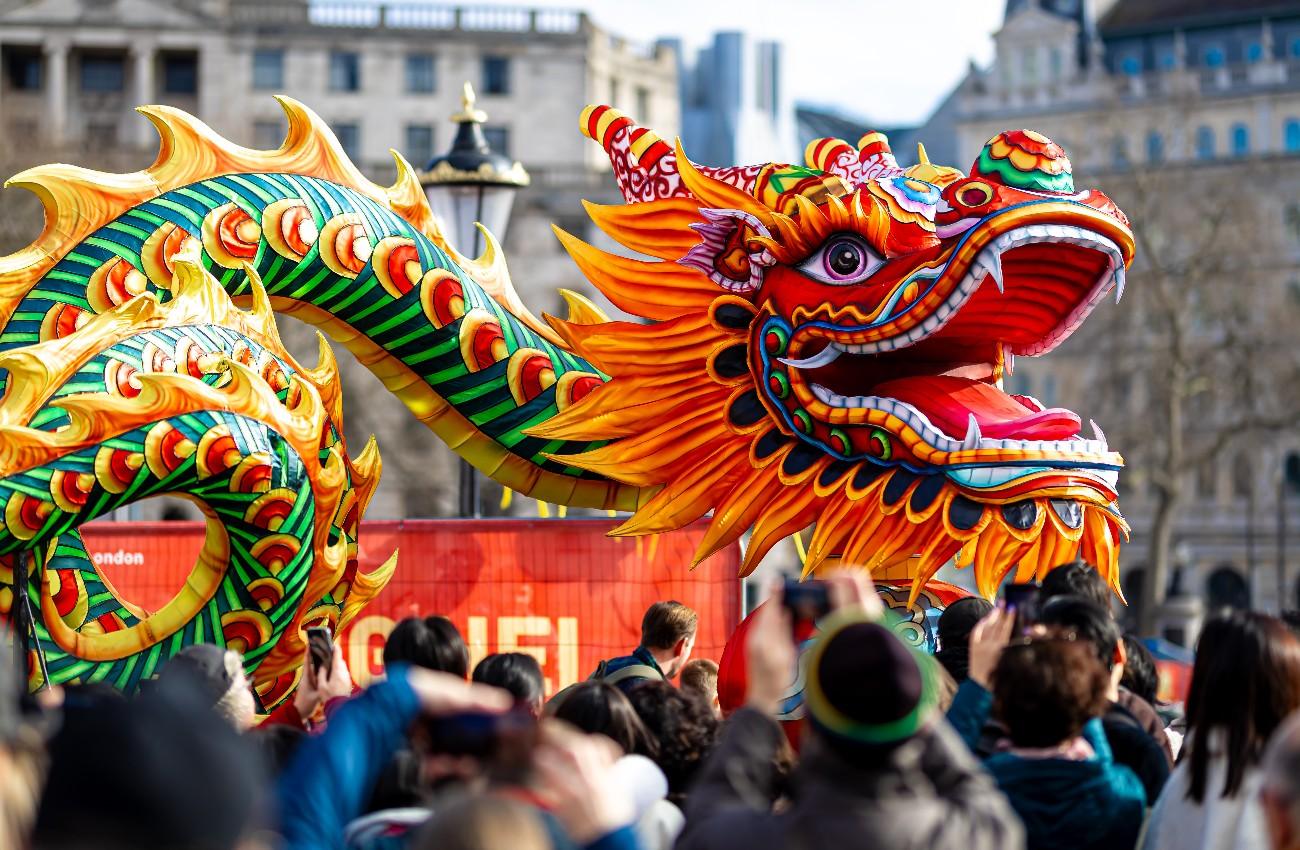 Close-up of a colourful dragon figure at a festive parade.