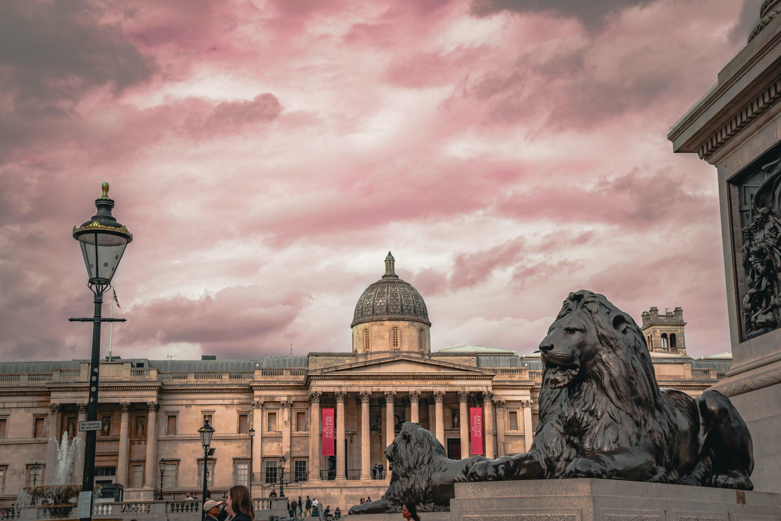 Close up of the Lion statue at Trafalgar square against a backdrop of a beautiful cloudy sky
