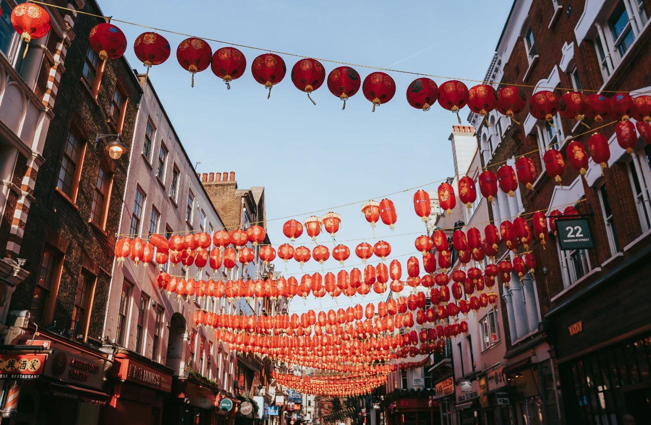 Rows of red lanterns hanging above a narrow Chinatown street.